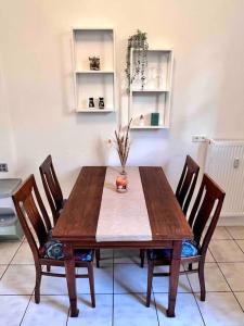 - une table à manger en bois avec des chaises et un vase dans l'établissement Gemütliches 1 Zimmer- Apartment in Neuenbürg, à Neuenbürg