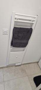 a white refrigerator with two towels in a room at Studio plein Sud au calme in Montauban