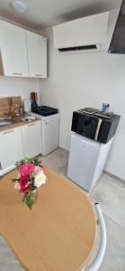 a kitchen with a table with a vase of flowers on it at Studio plein Sud au calme in Montauban