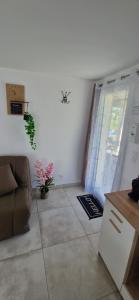 a living room with a couch and a sliding door at Studio plein Sud au calme in Montauban