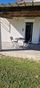 a picnic table and two chairs on a patio at Studio plein Sud au calme in Montauban