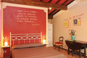 um quarto com uma cama com uma parede vermelha em Villa Poesie em Gallicano