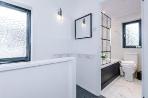 een witte badkamer met een toilet en een raam bij New 2 Bed House - Perfect for Contractors & Families By AV Stays Short Lets St Helens in Saint Helens