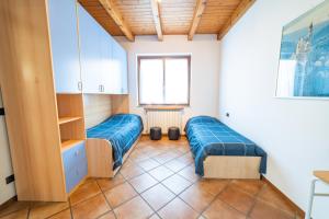 Habitación con 2 camas azules y ventana. en Casa Antonia Tra Laghi & Monti, en Armeno