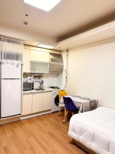 1 dormitorio con 1 cama blanca y cocina en #강남역 3분#편리한 교통#편안한 숙소, en Seúl