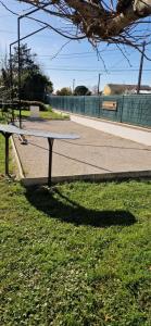 a bench sitting in the grass next to a street at Studio plein Sud au calme in Montauban