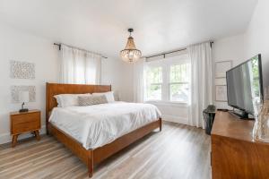 a bedroom with a bed and a flat screen tv at Cozy Home Near Fountain Square & 5 Min Lucas Oil in Indianapolis