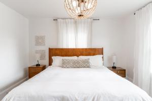 印第安納波利斯的住宿－Cozy Home Near Fountain Square & 5 Min Lucas Oil，卧室配有白色的床和吊灯。