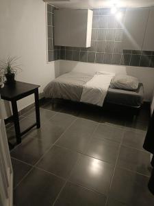 Un dormitorio con una cama y una mesa en una habitación. en Tiny house - Gare Paris Aeroport, en Drancy
