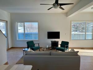 a living room with a couch and chairs and a flat screen tv at Ravens End in Dead Man's Flats