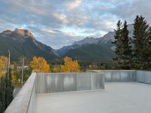 a balcony with a fence and mountains in the background at Ravens End in Dead Man's Flats