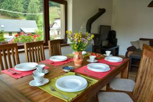 a wooden table with plates and napkins on it at Chata na Trávniku 302 in Horná Turecká