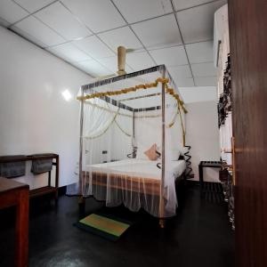 a bedroom with a canopy bed in a room at Etnico Surf Resort in Arugam Bay