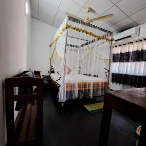 a bedroom with a bed and a ceiling fan at Etnico Surf Resort in Arugam Bay