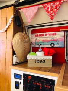 a small kitchen with a stove with books on it at Tommy, a '77 VW Bay stylish Van in Los Cristianos