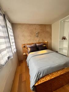 a bedroom with a large bed with a wooden bench at Appartement cosy près de la Seine in Boulogne-Billancourt