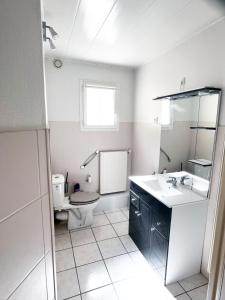 een witte badkamer met een toilet en een wastafel bij Emporium Néris - Premium Serviced Apartments in Néris-les-Bains