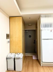 two trash cans in a room with a refrigerator at #Gangnam Station in Seoul