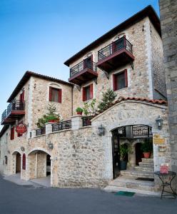 a large brick building with balconies on top of it at Amanites Guesthouse in Dimitsana