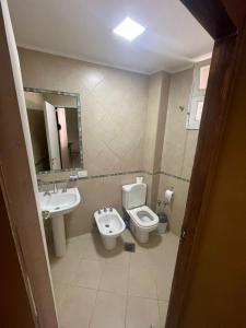 ein Badezimmer mit einem Waschbecken, einem WC und einem Spiegel in der Unterkunft Excelente casa en el centro de la ciudad in La Cieneguita