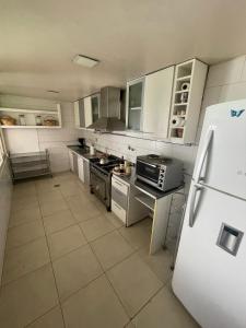 eine Küche mit weißen Geräten und einem weißen Kühlschrank in der Unterkunft Excelente casa en el centro de la ciudad in La Cieneguita