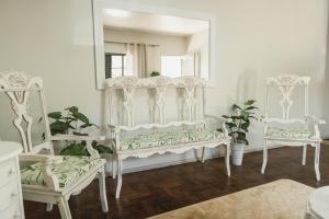 a room with two white chairs and a mirror at La Casina in Uruguaiana