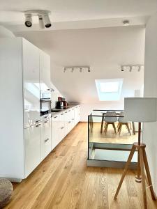 a kitchen with white cabinets and a glass table at Gmunden Skyline in Gmunden