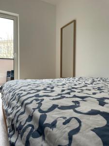 a bedroom with a bed with a blue and white comforter at Apartament Jarosław in Jarosław