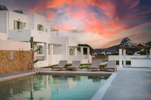 a villa with a pool with chairs and a sunset at Agalipa in Skiros
