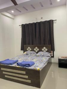 um quarto com uma cama com lençóis azuis em AnubhavGruha Holiday Home Nagpur em Nagpur