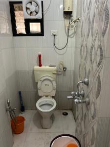 uma pequena casa de banho com WC e chuveiro em AnubhavGruha Holiday Home Nagpur em Nagpur