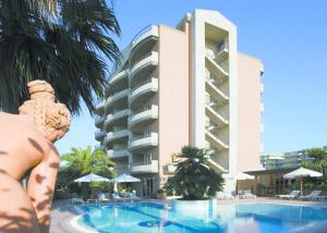 una statua di fronte a un edificio con piscina di Residence Torre Del Mar ad Alba Adriatica