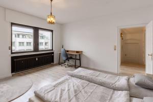 Habitación blanca con cama y escritorio. en Wohnung mit Küche, Balkon, Netflix im Herzen von Neheim, en Arnsberg