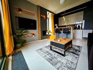 a living room with a coffee table and a kitchen at Apartamenty Point of View in Bydgoszcz