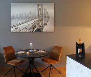 een eetkamer met een tafel en stoelen en een schilderij bij Ausblick Kleinjuwel mit Panoramablick + Garage in Merano