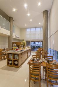 a large dining room with wooden tables and chairs at São Carlos Marklin Suítes in São Carlos