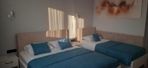 2 letti con cuscini blu in una camera da letto di Hotel Korona a Verbovatovka