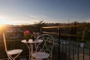 een tafel en stoelen op een balkon met uitzicht op de zonsondergang bij Casa Martina Tuscany in Certaldo