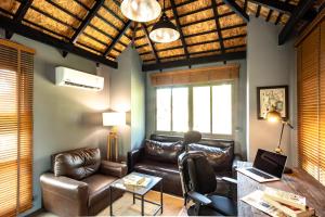 4BDR luxury pool villa & office space in Cherngtalay-Bangtao في Ban Phru Champa: غرفة معيشة مع أريكة جلدية وطاولة