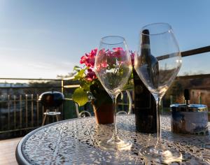 two wine glasses on a table with a bottle of wine at Casa Martina Tuscany in Certaldo