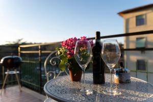 een tafel met twee wijnglazen en een vaas met bloemen bij Casa Martina Tuscany in Certaldo