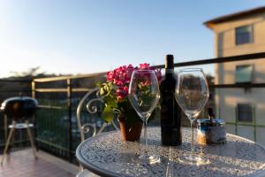 a table with two wine glasses and a vase with flowers at Casa Martina Tuscany in Certaldo