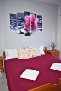 a bedroom with a bed with a pink flower on it at Venice Apartments in Limenaria