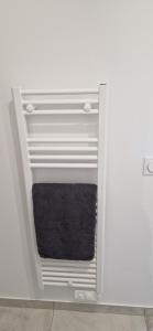 a towel rack in a bathroom with a black towel at Studio plein Sud au calme in Montauban