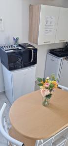 a table with a vase of flowers on top of it at Studio plein Sud au calme in Montauban