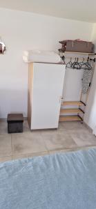 a room with a white refrigerator with a mattress on top at Studio plein Sud au calme in Montauban