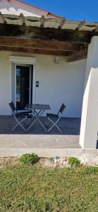 a patio with two chairs and a table in front of a house at Studio plein Sud au calme in Montauban