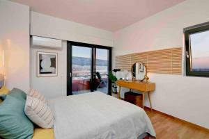 a bedroom with a bed and a desk and windows at Apollo Tower Athens Center 360oView Luxury Apt in Athens