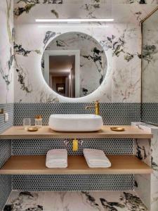 bagno con lavandino e specchio di Apollo Tower Athens Center 360oView Luxury Apt ad Atene