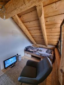 een slaapkamer met een bed en een stoel in een kamer bij Vila Vrhi in Pregrada